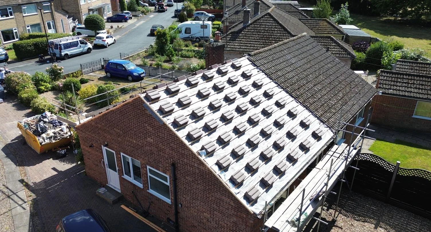 Roofing installation in progress with membrane and tiles prepared